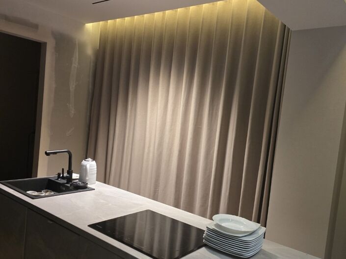 Elegantes Wohnzimmer mit grau-beigen Vorhängen, die die Fenster vollständig bedecken