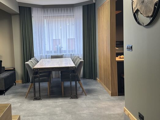Modernes Wohnzimmer in Warm-Eukalyptus-Tönen mit Vorhängen in Flaschengrün