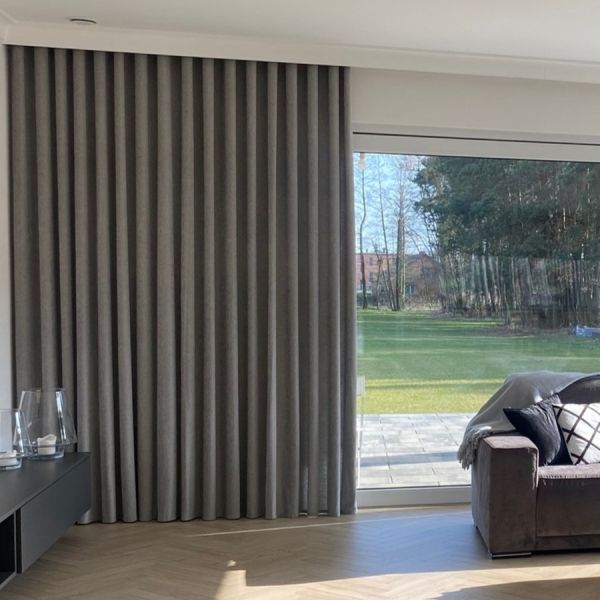 Ein breiter Vorhang für das Wohnzimmer, perfekte Ausrichtung der Falten.